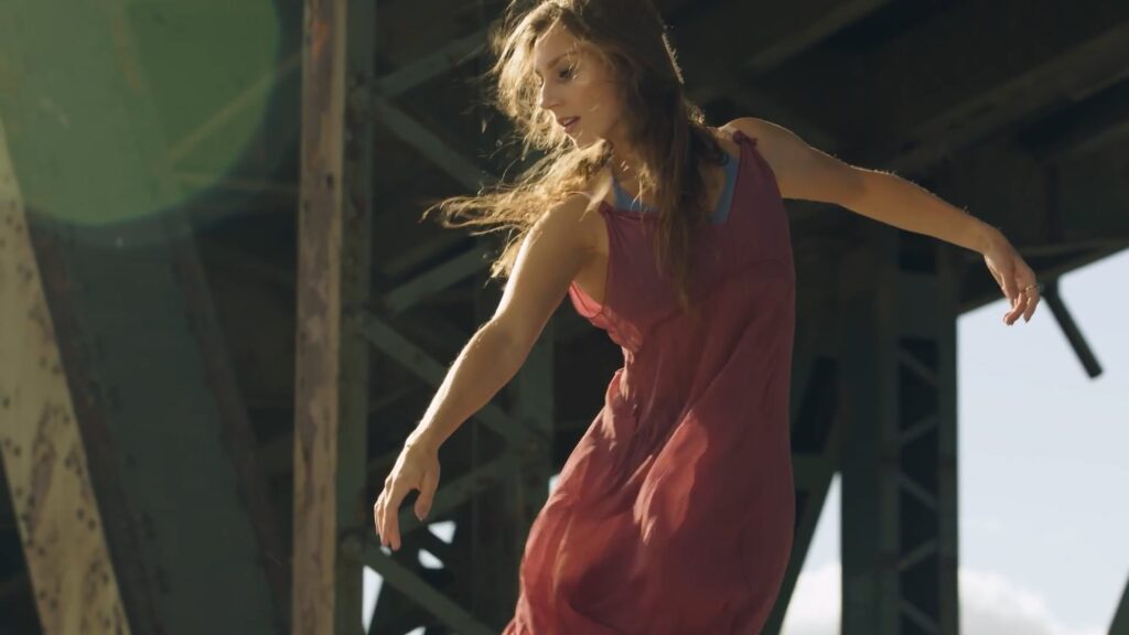 Contemporary dancer performs outdoors beneath a bridge, capturing movement, grace, and artistic expression in natural light.