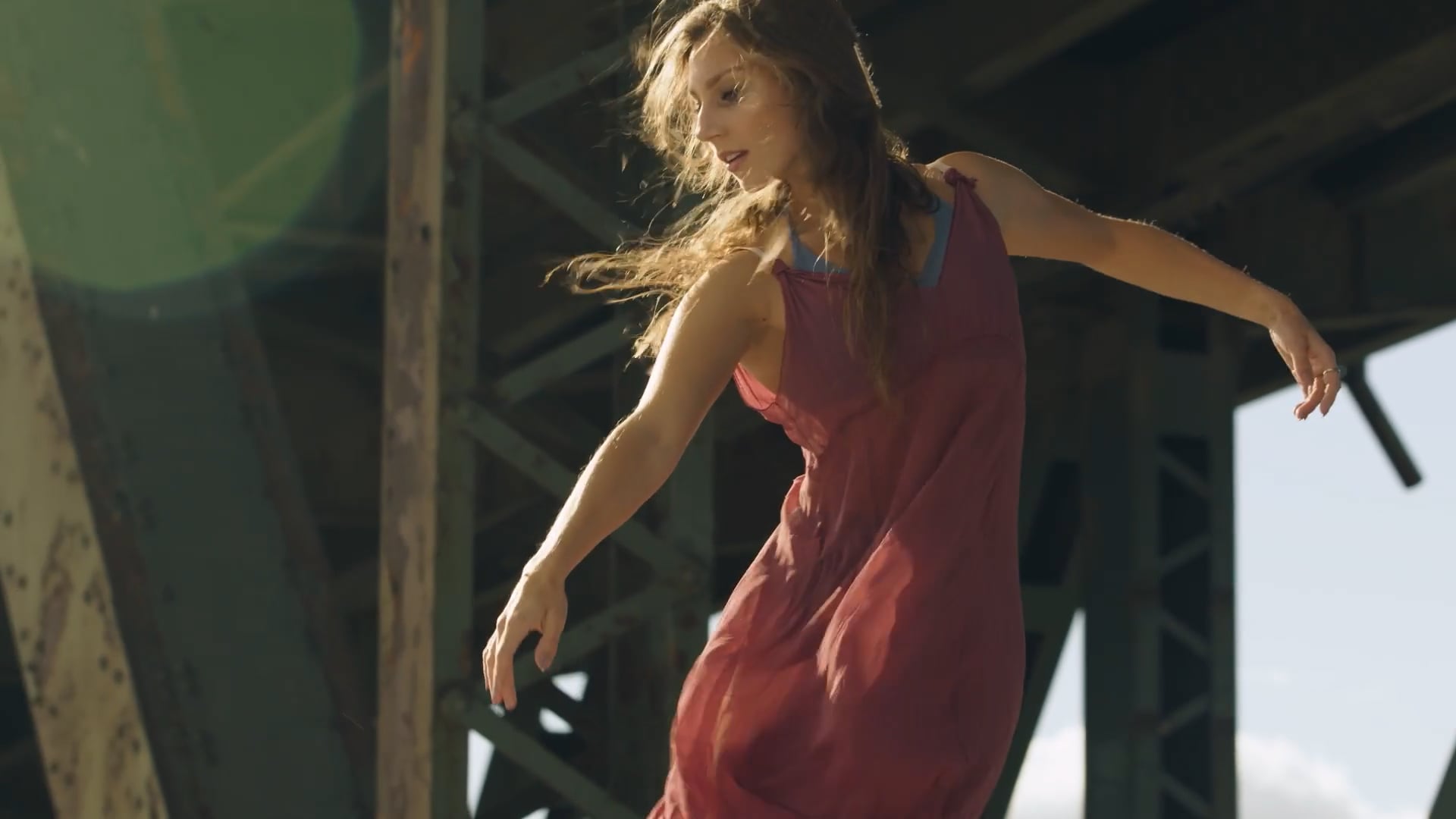 Contemporary dancer performs outdoors beneath a bridge, capturing movement, grace, and artistic expression in natural light.