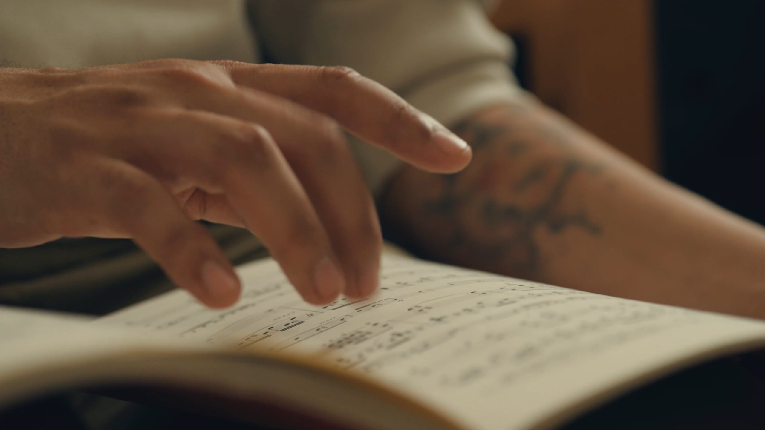 Close-up of a student’s hand turning sheet music during music study or performance practice.